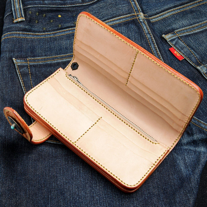 The unlined natural leather interior of the tooled wallet, showing the card slots and zip pocket.