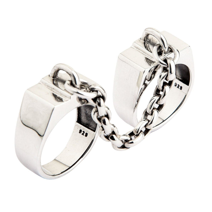 The two silver handcuff rings stacked to show their thickness and polished finish.