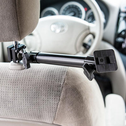 A Heavy-Duty Headrest Mounting Pedestal with 10 Arm is attached to the back of a beige seat, supporting a device holder, with the steering wheel and dashboard visible in the background.