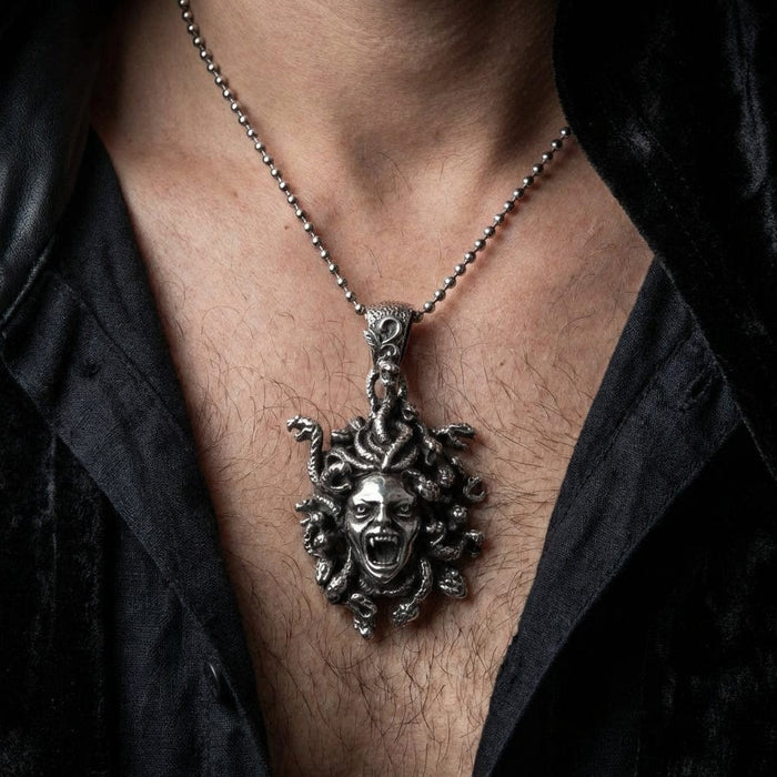 The 33-gram Medusa necklace worn on a man's chest to show scale and drop length