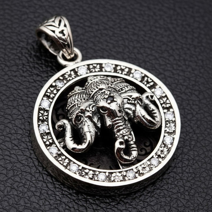 The Ganesha elephant silver medallion pendant shown on a black leather surface.