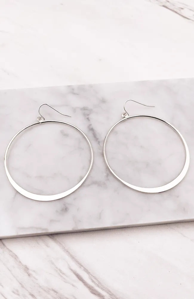 Elegant silver hoop style earrings displayed in a stylish product presentation