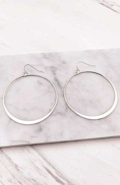 Elegant silver hoop style earrings displayed in a stylish product presentation