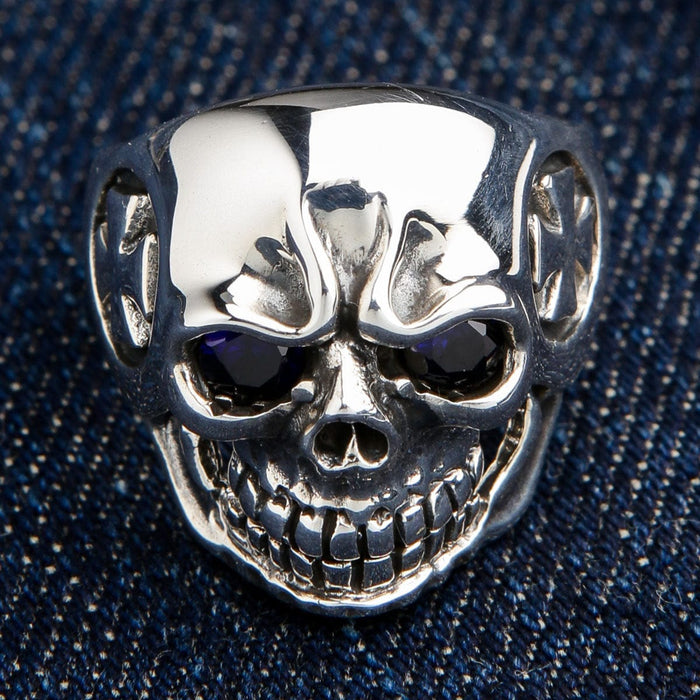 Front view of the solid 925 sterling silver iron cross skull ring with sparkling blue eyes.