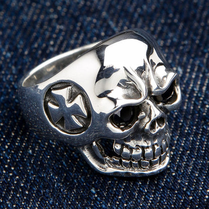 An angled, three-quarter view of the men's biker skull ring with blue stone eyes.