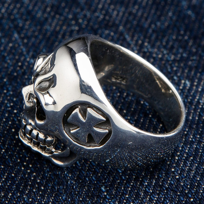 Angled on denim, a raised cross sits in the recessed circle on the side band beside a 925 stamp.