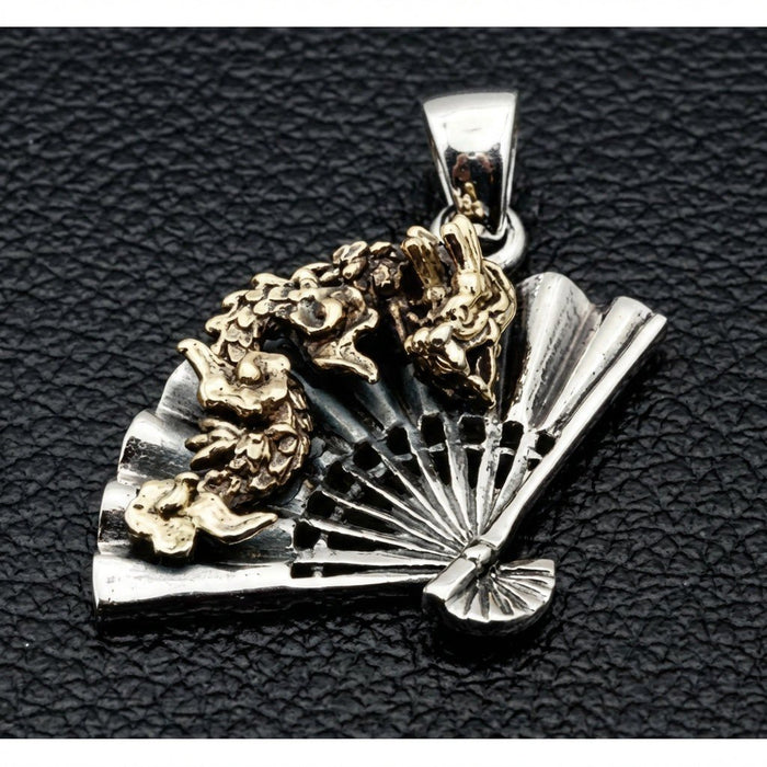Angled view of brass dragon overlay winding across sterling silver folding fan gothic pendant on black leather
