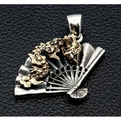 Angled view of brass dragon overlay winding across sterling silver folding fan gothic pendant on black leather