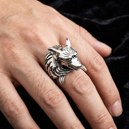 Massive sterling silver kitsune fox ring worn on middle finger against black velvet, showing sculptural scale and snarling wolf-like detail