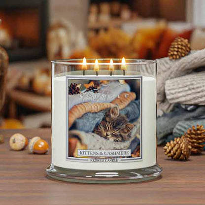 Kringle Candle 4-wick kitten and cashmere lit candle on a wooden surface with a cozy background.