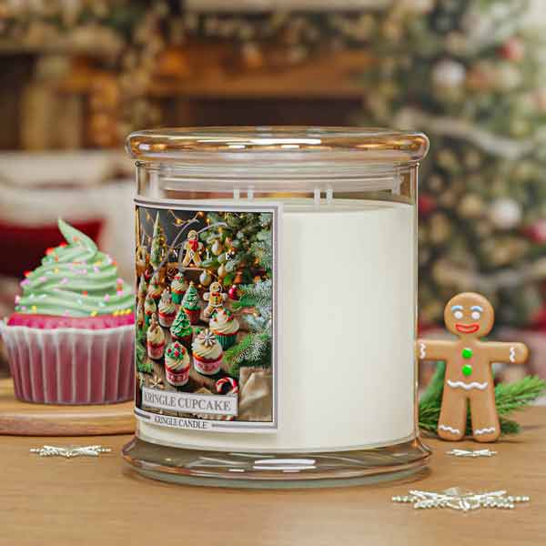 Candle jar labeled 'Jingle Cupcake' with a festive design, surrounded by Christmas-themed items on a wooden surface.