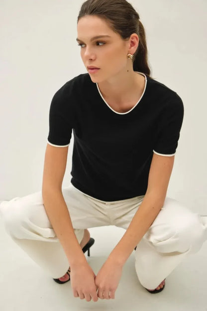 Black layered look essential short sleeve sweater top with white trim on neckline and sleeve cuffs