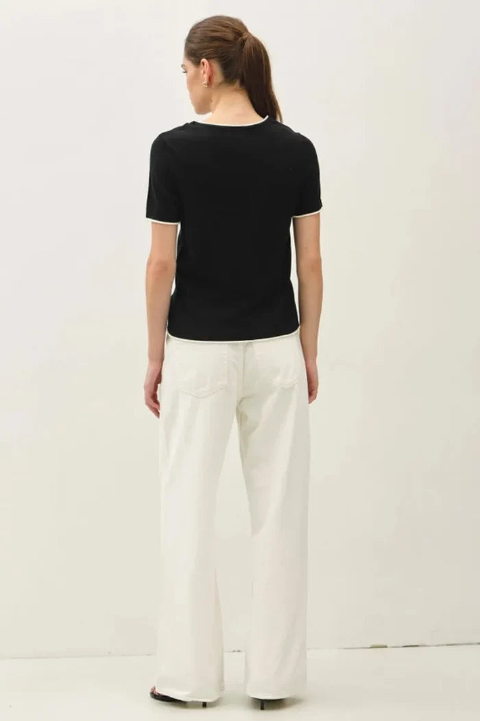 Black essential short sleeve sweater top with white trim on neckline and sleeve hems for layered look essential short sleeve