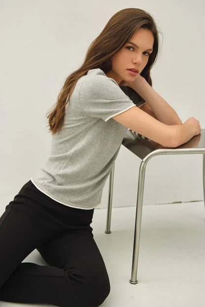 A soft gray essential short sleeve sweater top with white trim along sleeves and hem for layered looks
