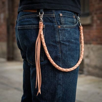 Light tan braided leather wallet chain attached to dark blue jeans showing how it drapes from belt loop to back pocket