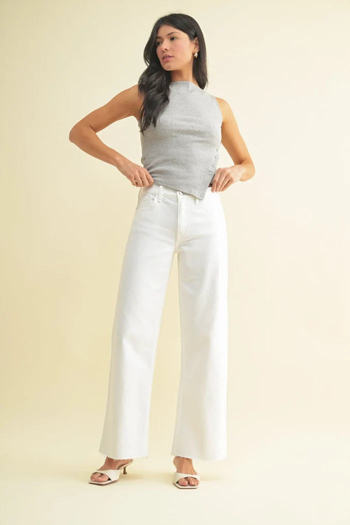 Women’s sleeveless grey mock neck top with asymmetrical hem paired with longer length wide leg denim