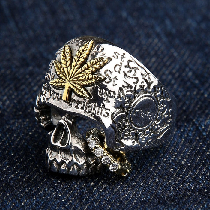 Side angle of handcrafted skull ring showing brass cannabis leaf detail and ornamental engravings