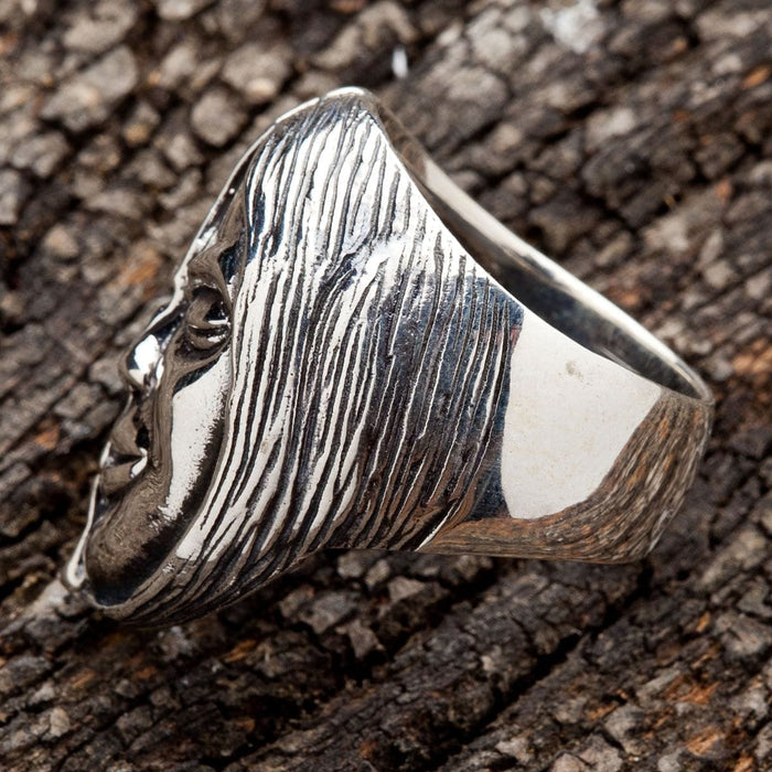 A gothic biker ring featuring a half-skull, half-face design, handcrafted in solid silver.