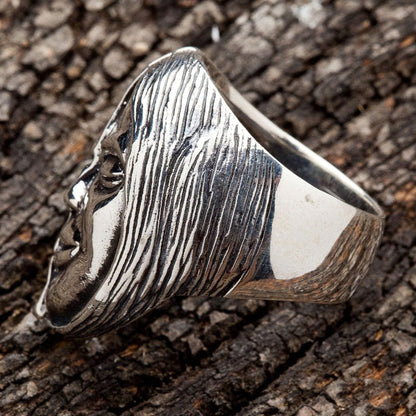 A gothic biker ring featuring a half-skull, half-face design, handcrafted in solid silver.