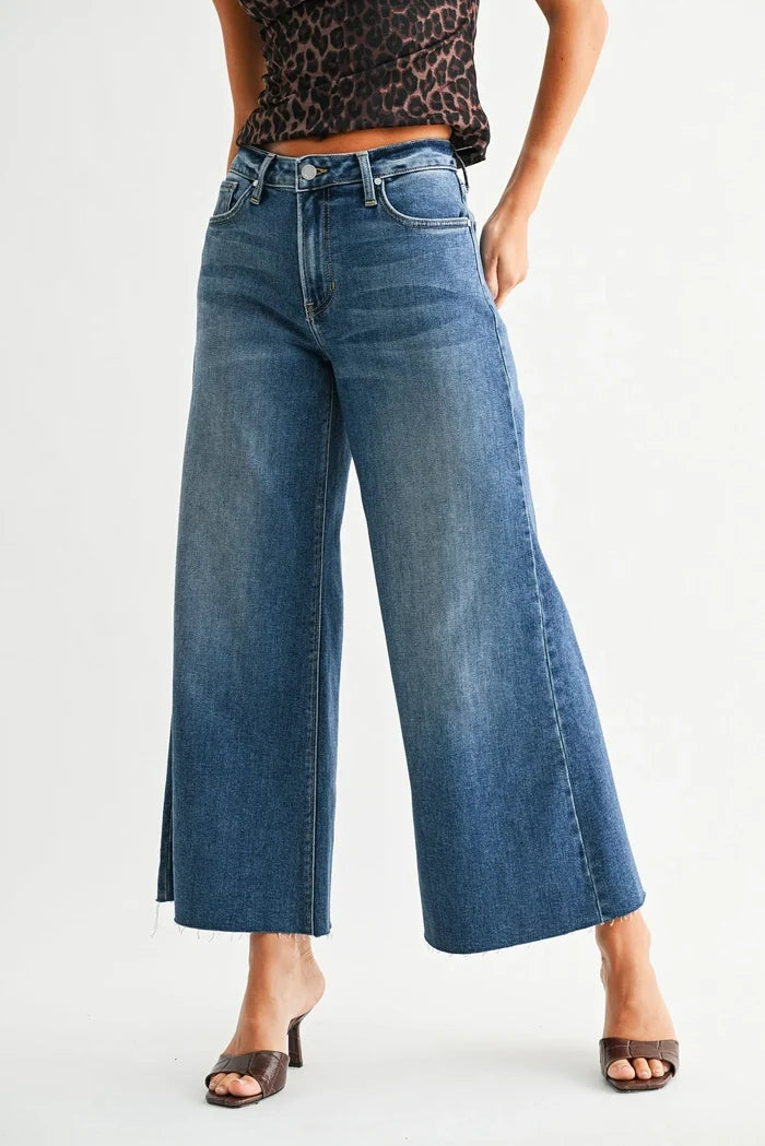 Mid rise wide leg flare crop denim jean in mid-wash blue with frayed hem