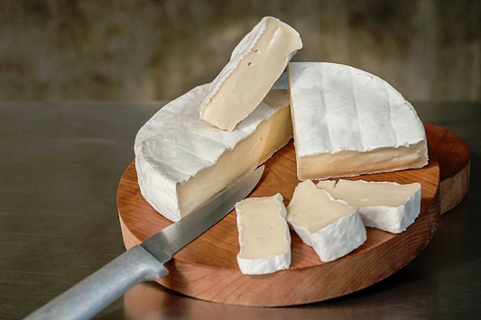 Moses Sleeper cheese from Jasper Hill Farm, Vermont, soft-ripened with white rind on wooden board.
