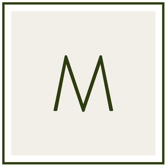 Monogram M in dark green on a pale beige background