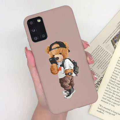 a woman holding a phone case with a teddy bear