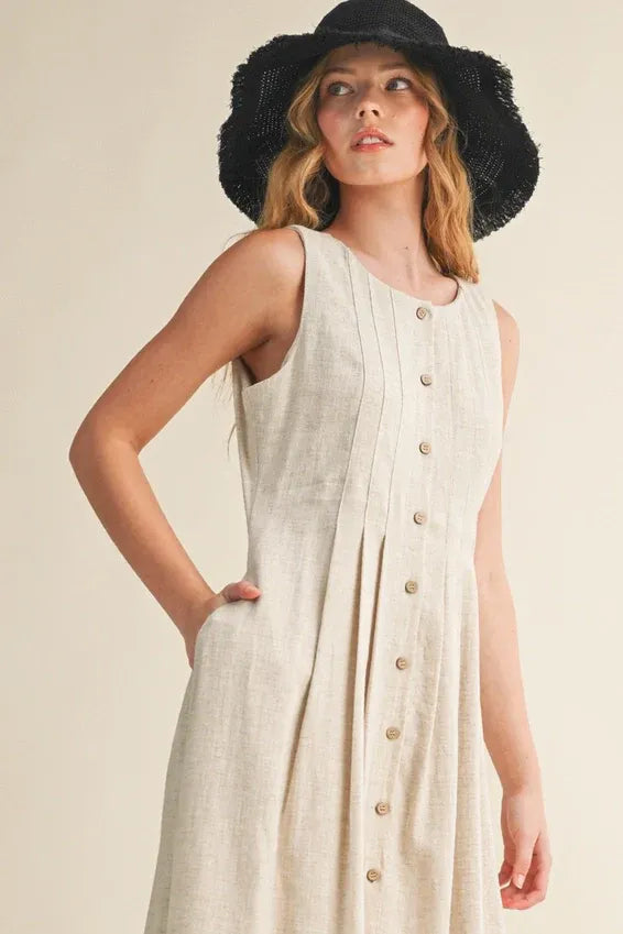 Sleeveless off-white linen maxi dress with button front and pleats
