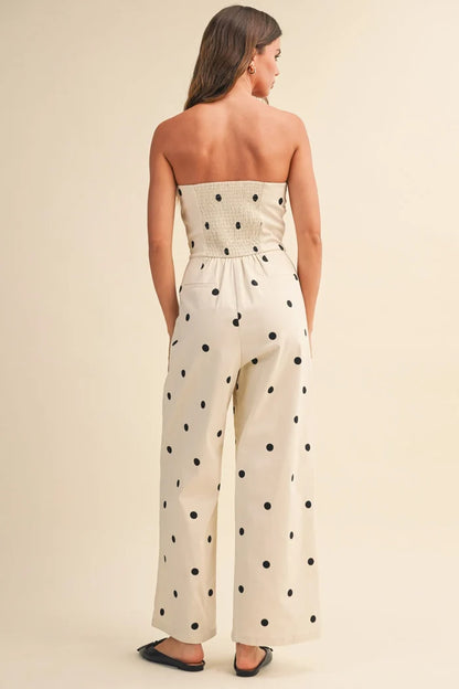 A strapless off-white polka dot stretch twill jumpsuit with smocked waistband and wide leg design