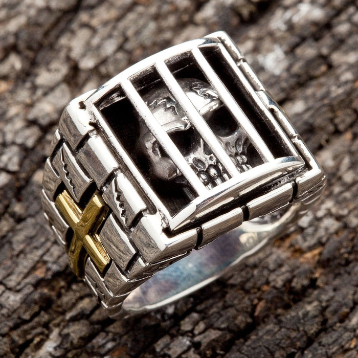 A unique sterling silver prison ring with a skull held captive inside, a powerful symbol of an unbreakable spirit.