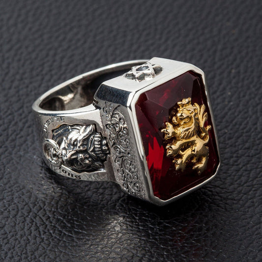 A men's solid silver signet ring featuring a golden brass rampant lion emblem on a large red stone.