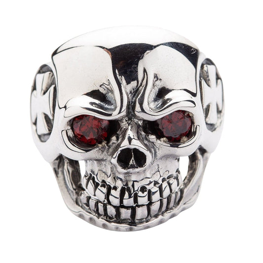 Direct front view of a grinning skull ring with red garnet-colored eyes, emphasizing the aggressive teeth and nose detail.