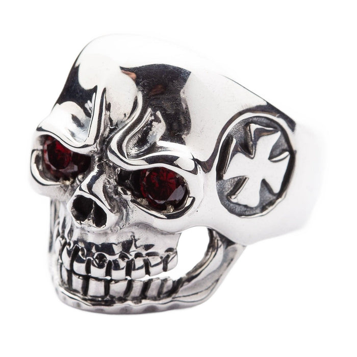 Angled view of a men's gothic skull ring featuring deep red stone eyes and a polished silver finish.