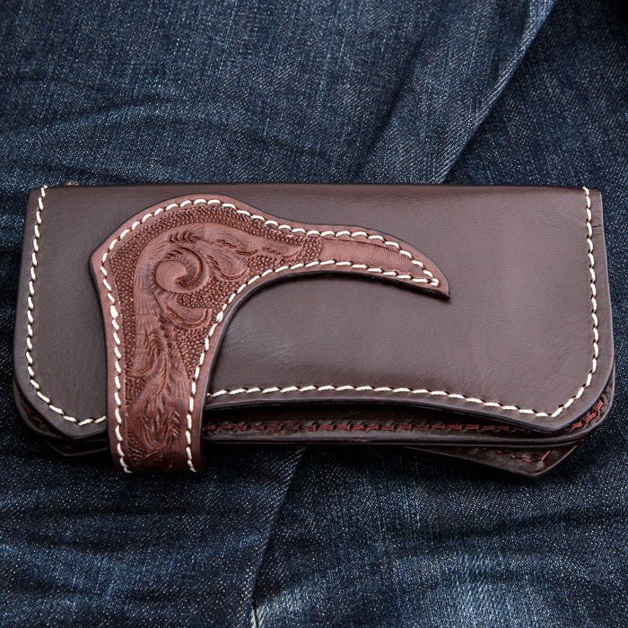 Front face with the tooled strap crossing it, layered leather edges showing darker stitching along the base.