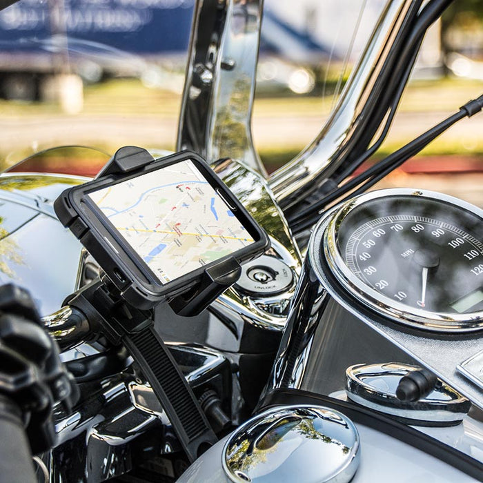 The RoadVise® Motorcycle Phone Mount with Strap is secured to a motorcycle’s handlebars, showing a map on the phone screen with the speedometer and chrome features visible nearby.
