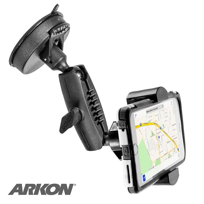 A black RoadVise® Phone Holder with a suction mount and adjustable arm securely holds a smartphone displaying a map navigation app, with the RoadVise® logo in the lower left corner.