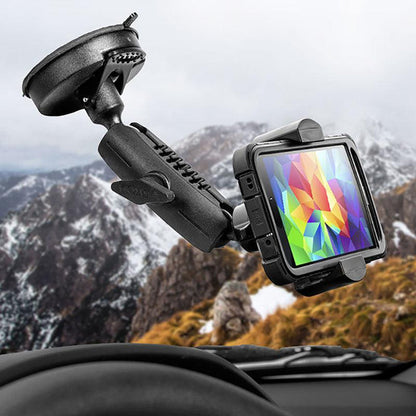 The RoadVise® Phone Holder with Suction Mount and Adjustable Arm is attached to the windshield, securely holding a phone with a vibrant screen, as snow-capped mountains and cloudy skies appear outside the car window.