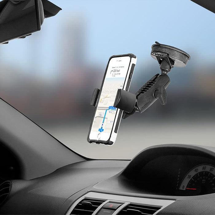 A RoadVise® Phone Holder with Suction Mount and Adjustable Arm secures a smartphone to a car windshield, displaying GPS navigation with the dashboard and speedometer partially visible.