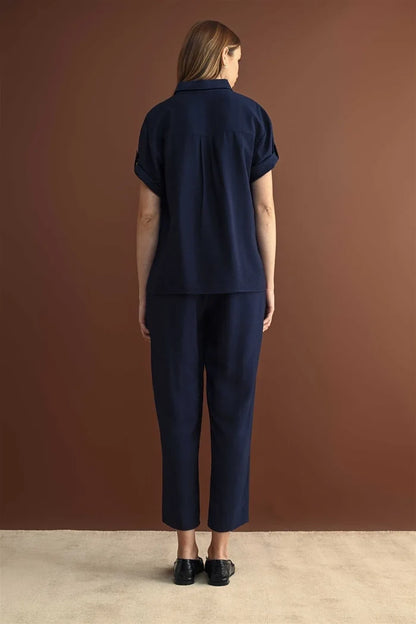 Navy blue short sleeve button down shirt with rolled cuffs paired with matching cropped trousers in cotton fabric