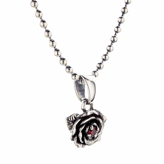 A detailed overhead view of the sterling silver floral pendant, designed as a rose with a fiery garnet gem.