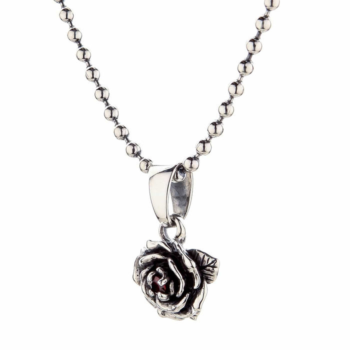 A side view of the silver rose pendant showing the polished bail and the three-dimensional quality of the petals.