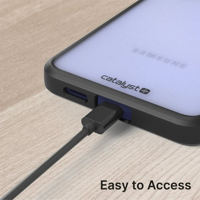 A black charging cable connects to a Samsung Galaxy S24 in a Catalyst Case US Impact Protection Case, resting on a wooden surface. The frosted back shows the Samsung logo. “Easy to Access” text appears in the bottom right corner.