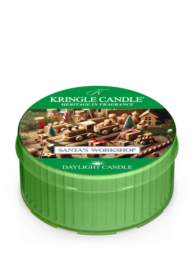 Green daylight of Kringle Candle featuring "Santa's Workshop" design with toys and trees, labeled "Daylight Candle."