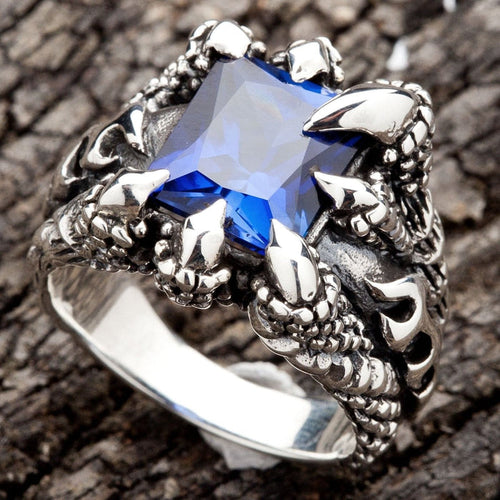 A men's solid sterling silver ring featuring four monstrous claws clutching a massive, square-cut blue sapphire CZ stone.