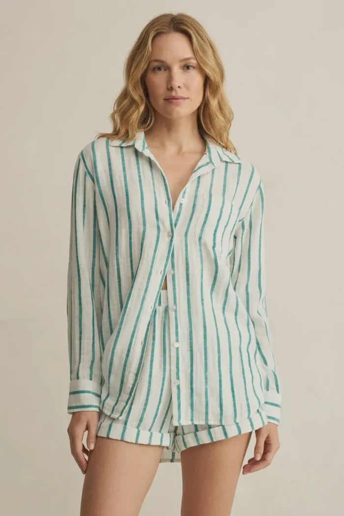A woman wears a loose saturdays stripe button long-sleeved shirt with vertical green and white stripes