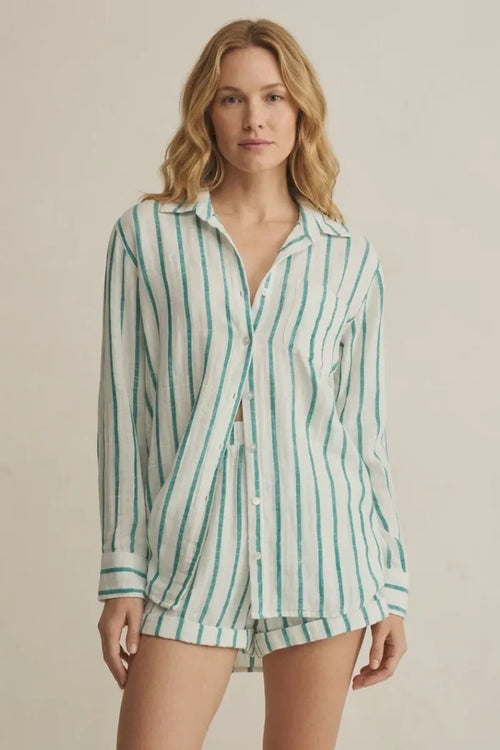 A woman wears a loose saturdays stripe button long-sleeved shirt with vertical green and white stripes