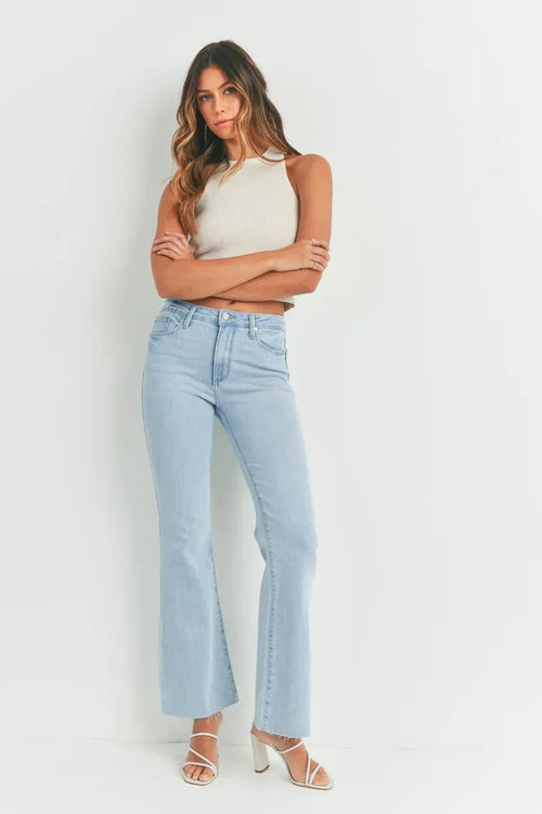 Woman in light blue jeans with scissor cut flair from Shop Daisy’s women’s boho chic clothing