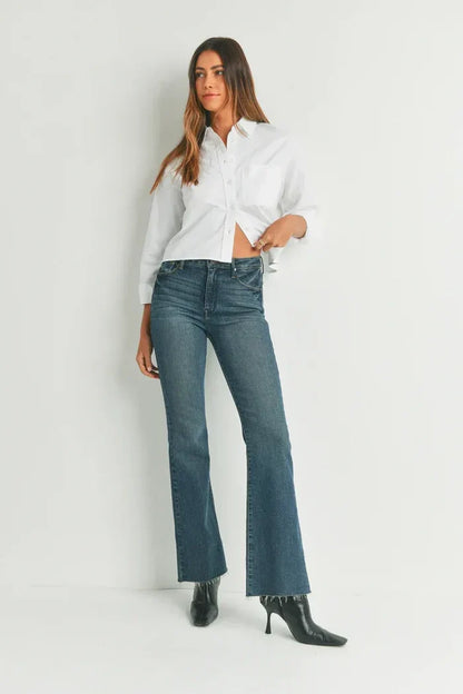 Woman in white shirt and blue jeans showcasing HR Scissor Cut Flare Denim, shop Daisy