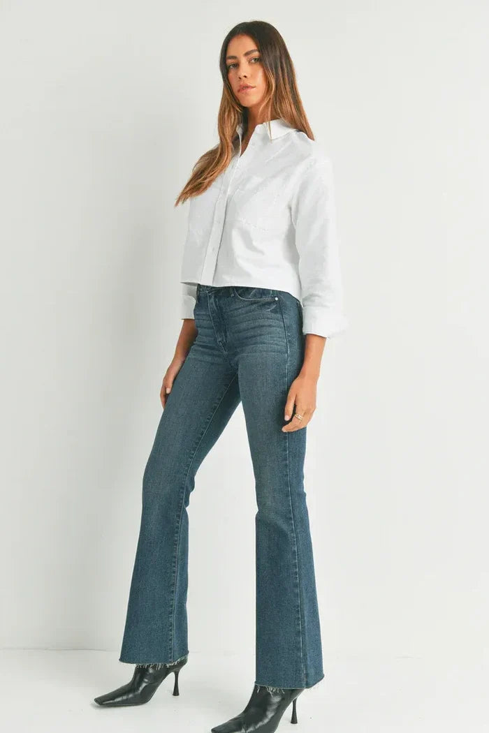 Woman in a white shirt and blue jeans showcasing HR SCISSOR CUT FLARE DENIM from Shop Daisy