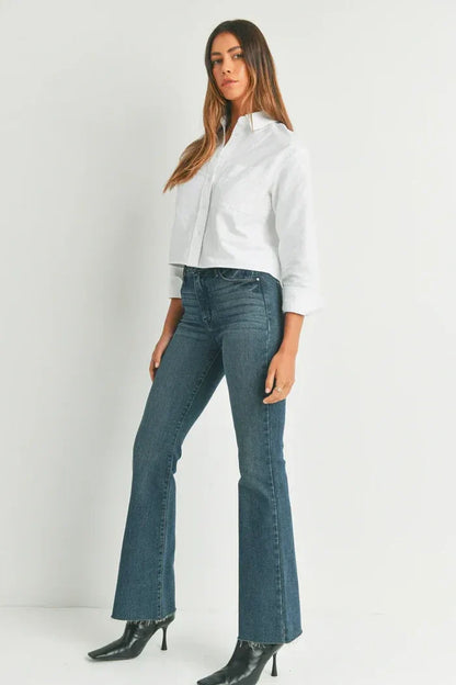 Woman in a white shirt and blue jeans showcasing HR SCISSOR CUT FLARE DENIM from Shop Daisy